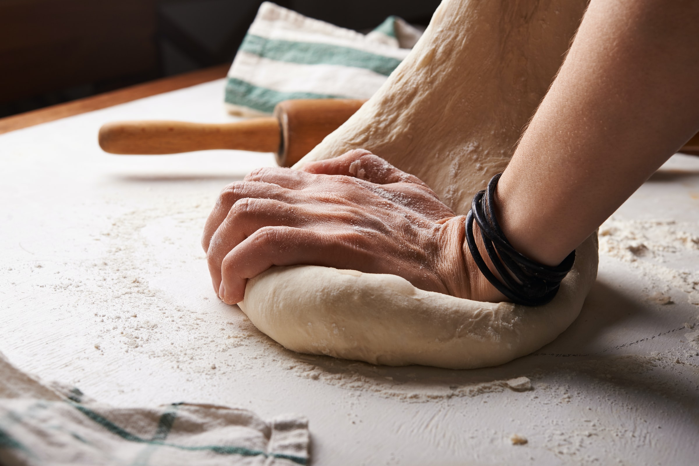 Baker's hands kneading bread dough for bread week